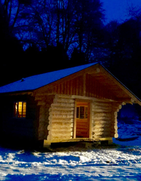 Canadian log cabin fishing hut at night . Nearly finished