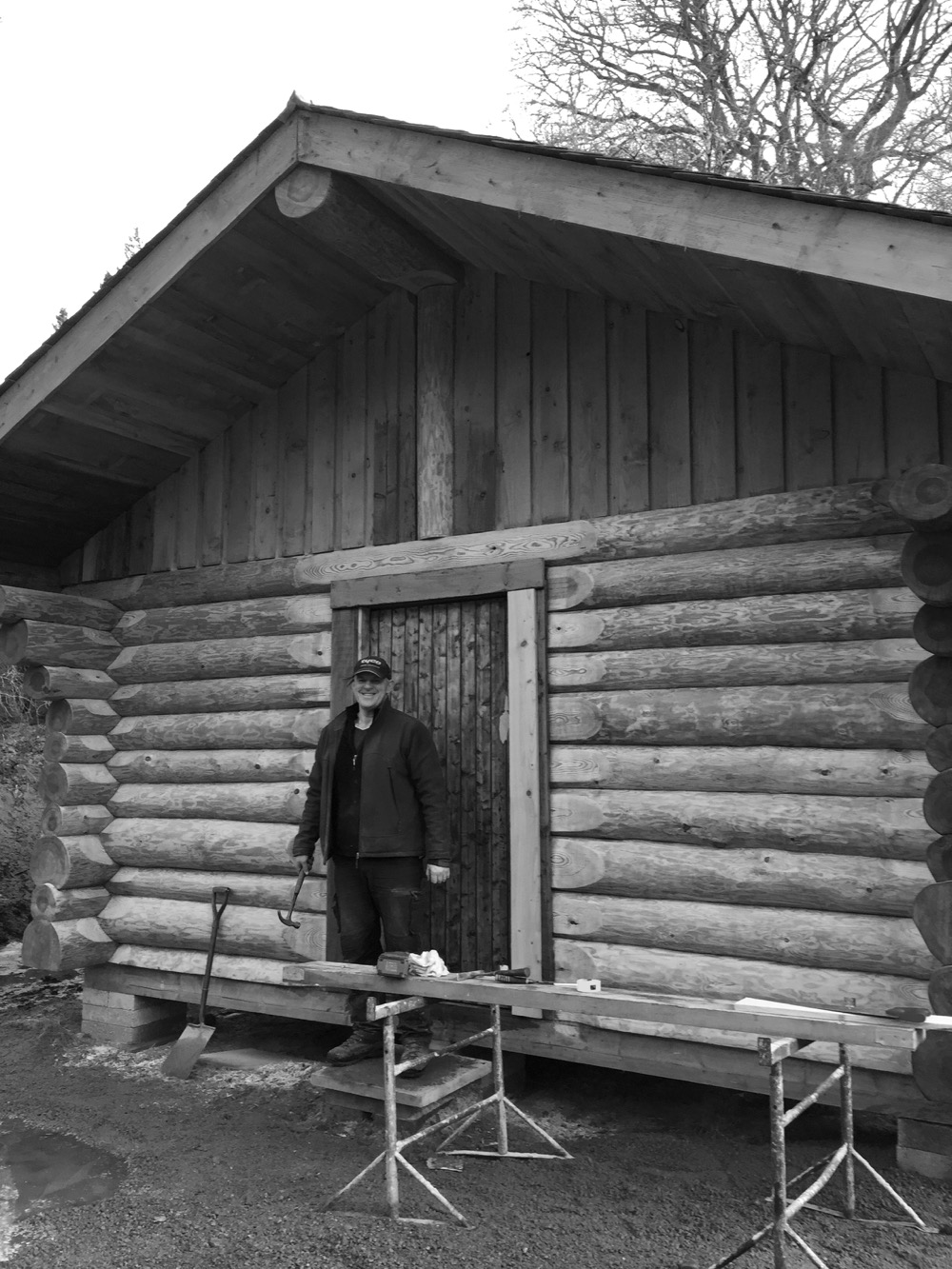 Ewen in front of the Canadian log cabin he built