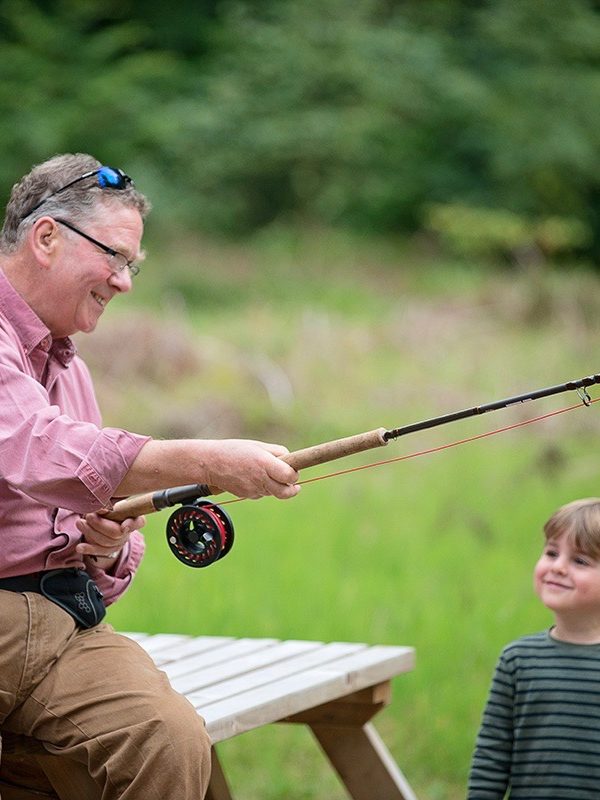 grandfather with grandson learning to fish
